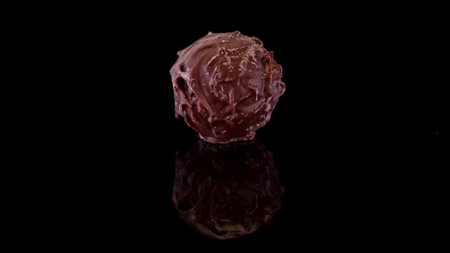 Chocolate praline, made with best cocoa. Nicely decorated, premium belgian or swiss chocolate confectionary rotating on a blach background.