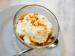 Popular English dessert Banoffi in a glass, mage from cookies with bananas and cream