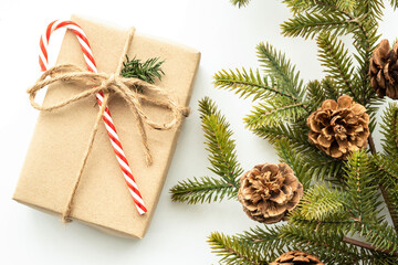 Beautiful Christmas background with gift box, decorate with pine branch and pine cone over white background. Top view with copy space, flay lay.