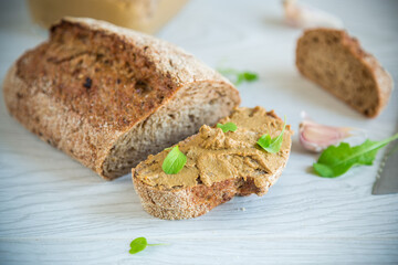 homemade liver pate with bread on a wooden table