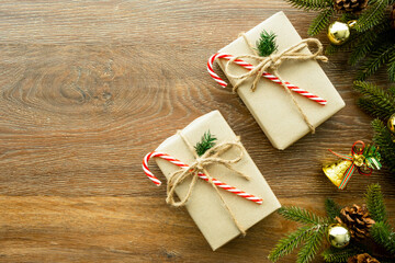 Beautiful Christmas background with two gift boxes, decorate with pine branch and pine cone over wood background. Top view with copy space, flay lay.