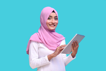 young muslim girl wearing pink hijab holding tab indian pakistani model