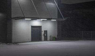 Loading port of a warehouse. Night photo, snowy parking lot.