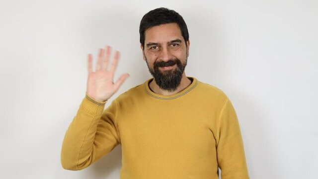 Friendly man smiling waving with hand looking at camera, glad to see you, saying hi or good bye. Isolated on white background.