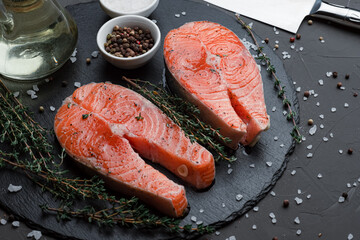 salmon steak, marinade, on a black background with salt and pepper, raw salmon steak
