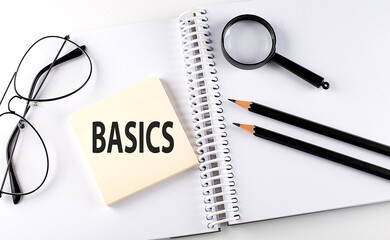 Word BASICS on the sicker on the notebook with pencils,magnifier and glasses