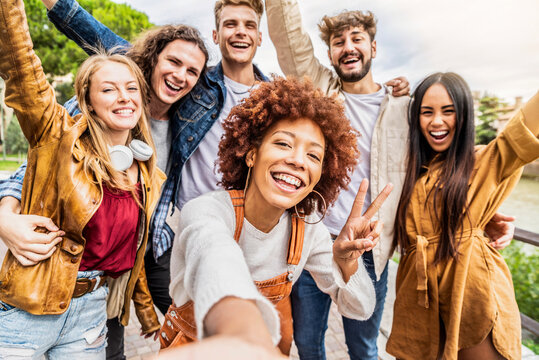 Multicultural best friends having fun taking group selfie portrait outside - Smiling guys and girls celebrating party day hanging out together on city street - Happy lifestyle and friendship concept