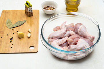 Pieces of cut chicken, spices, vegetable oil. Preparing to marinate the chicken.