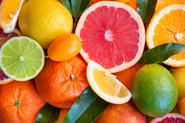 Fresh various citrus fruits with leaves, bright food background