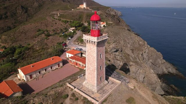 Long spiral aerial shot of the Cap Bear lighthouse and the coastline, south of France