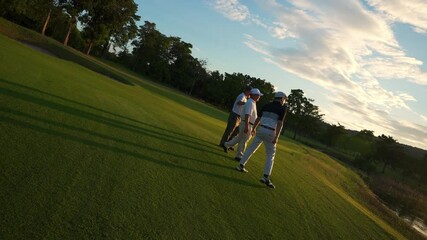 4K Group of Asian people businessman and senior CEO enjoy outdoor sport lifestyle golfing together at golf country club. Healthy men golfer walking on fairway with talking together at summer sunset