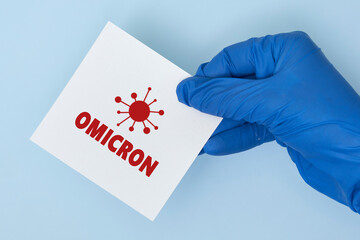 Doctor hand holds a card with text - New covid variant Omicron. Covid-19 new variant - Omicron....
