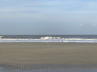 Eine Welle bricht auf der Sandbank vor der Nordseeinsel Borkum. 
