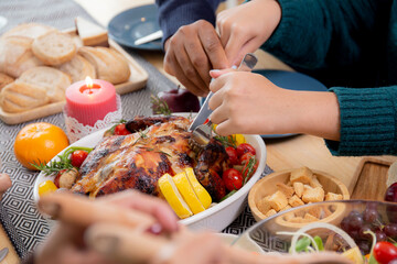 Closeup hands of children using knife slicing meat of turkey roasted on dishes for eating at home on thanksgiving eve day, celebration of xmas with dining with family, new year, festive and holiday.