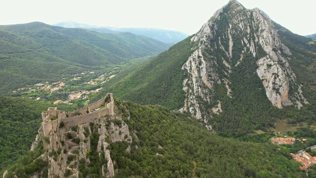 Aerial shot showing the Medieval Puilaurens castle and the Canigou mount in the Pyrénées mountain, France