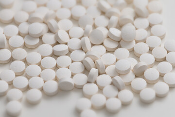 Fototapeta na wymiar A lot of white round pills on white background. Vitamin pills.