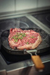 Raw beef steak fillet with ingredients like sea salt, pepper, onion and herbs on black board, product image for restaurant