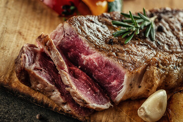 Grilled beef steak fillet with ingredients and herbs on black board, product image for restaurant
