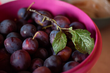 a container with a ripe plum is on the table