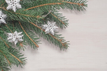 Winter background with pine branches, cones, white wooden replica space, holiday card