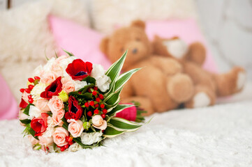 bouquet of flowers with roses and tulips on a blurry background with teddy bears