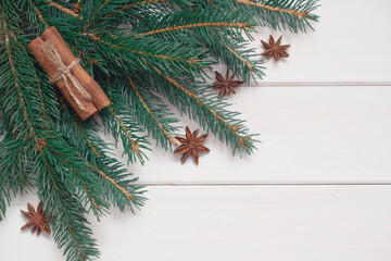 Winter background with pine branches, cones, white wooden replica space, holiday card