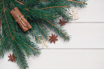 Winter background with pine branches, cones, white wooden replica space, holiday card