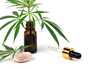 Cannabis leaf and vial. Serum, cosmetics, hemp oil. Bottle or vial with a dropper and hemp leaf  isolated on white background close up. Natural cosmetics concept.
