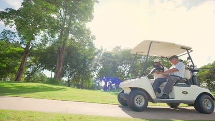 Group of Asian people businessman and senior CEO enjoy outdoor activity lifestyle sport golfing together at golf country club. Healthy men golfer driving golf cart on golf course in summer sunny day - Powered by Adobe