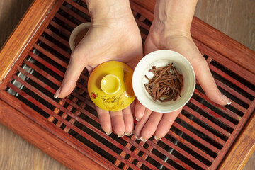 Top view tea set a wooden table for tea ceremony background. Woman holding a cup of tea