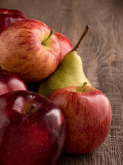 Yellow pears and red apples fruits on black plate.