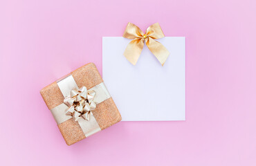 
blank blank card with gift and on pastel pink background with place for text