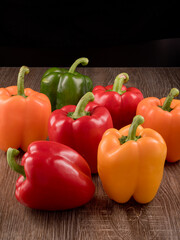 Peppers of differents colors. Vegetables on wooden table.