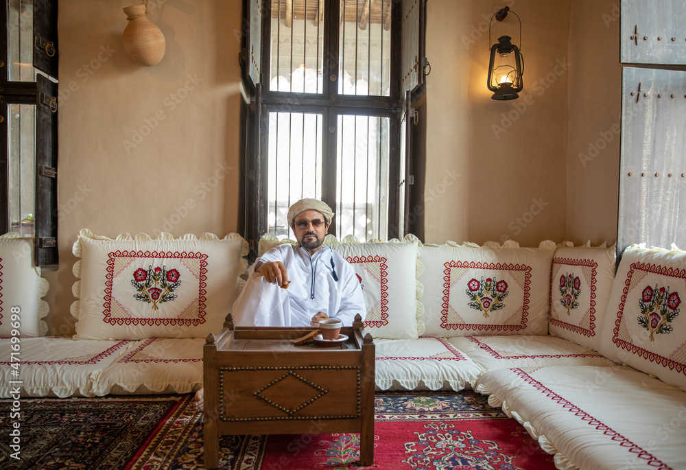 Poster Arab man drinking arabic coffee in al seef district in Dubai