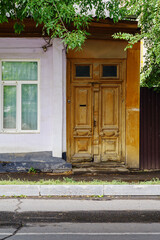Window and old carved wooden door, a fragment of an old building. The picture was taken in Russia, in the city of Orenburg