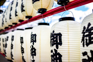 Kyoto, Japan with Hirano jinja shrine temple with closeup of many paper lights in row with blue sky in background
