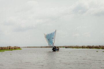 Hand made pirogues or sail boats on Lake Nokoue heading home after a trip to the market. Ganvié,...