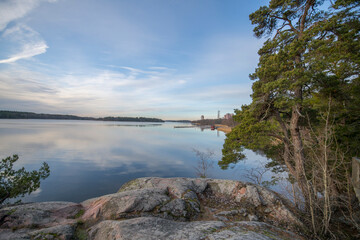View at the lake Mälaren a Pale Winter solstice day, rocks trees and apartment houses in the district Bromma in Stockholm