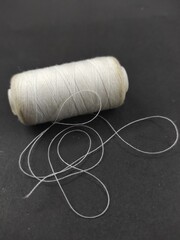 Photo of white sewing thread spool isolated on black background, Not Focus