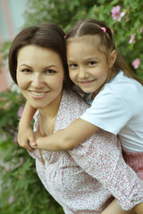 Happy mother and daughter posing in the park