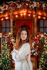 A beautiful girl portrait in a Christmas interior. Christmas tree, decorated fireplace, lots of gifts, Christmas theme. Cozy atmosphere.