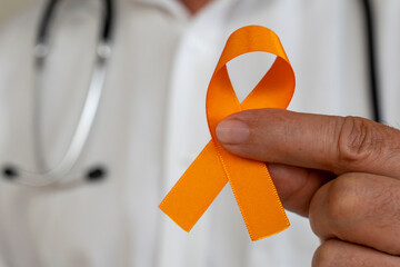 December orange. doctor holding orange ribbon. campaign to prevent skin cancer, melanoma, 