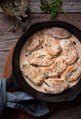 Cooked chicken breast with creamy sauce in frying pan