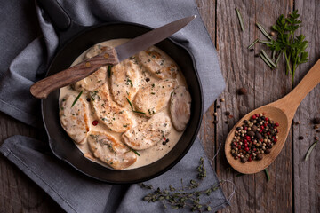 Cooked chicken breast with creamy sauce in frying pan