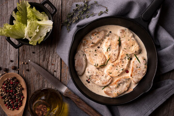 Cooked chicken breast with creamy sauce in frying pan