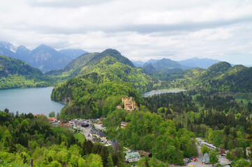romantic medieval Wittelsbach Hohenschwangau Castle (Schloss Hohenschwangau) in the Bavarian Alps and lakes Alpsee and Schwansee in the background (Hohenschwangau, Schwangau, Bavaria, Germany)	