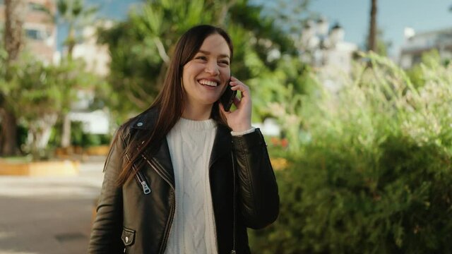 Young hispanic woman smiling confident talking on the smartphone at park