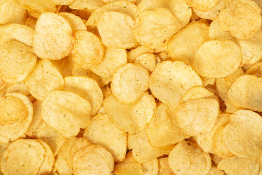 Crispy fresh potato chips, snacks background. Top view, flat lay.
