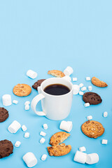 Cup of coffee, marshmallow, cookies on a blue background.