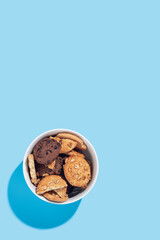 Hand made cookies in a white bowl on a light blue background. Top view, flat lay.